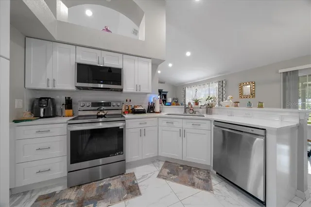 a kitchen with white cabinets stainless steel appliances and sink