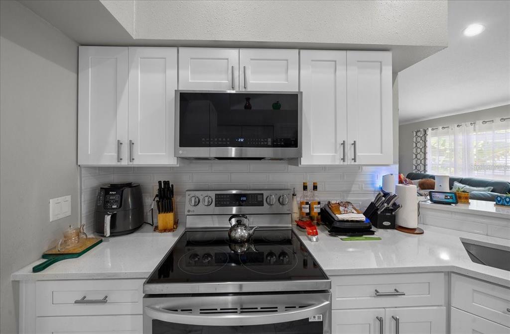 4997 Southwest 107th Loop Ocala, FL 34476 - Photo 15 of 48 a kitchen with a sink a stove and cabinets