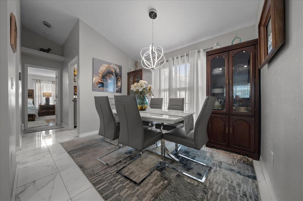 4997 Southwest 107th Loop Ocala, FL 34476 - Photo 17 of 48 a view of a dining room with furniture window and wooden floor