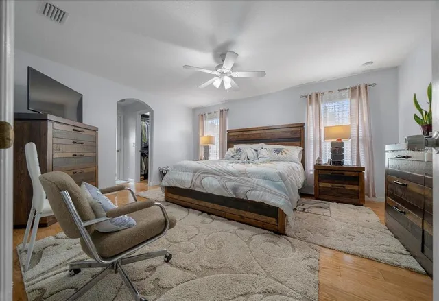 a bedroom with a bed and wooden floor