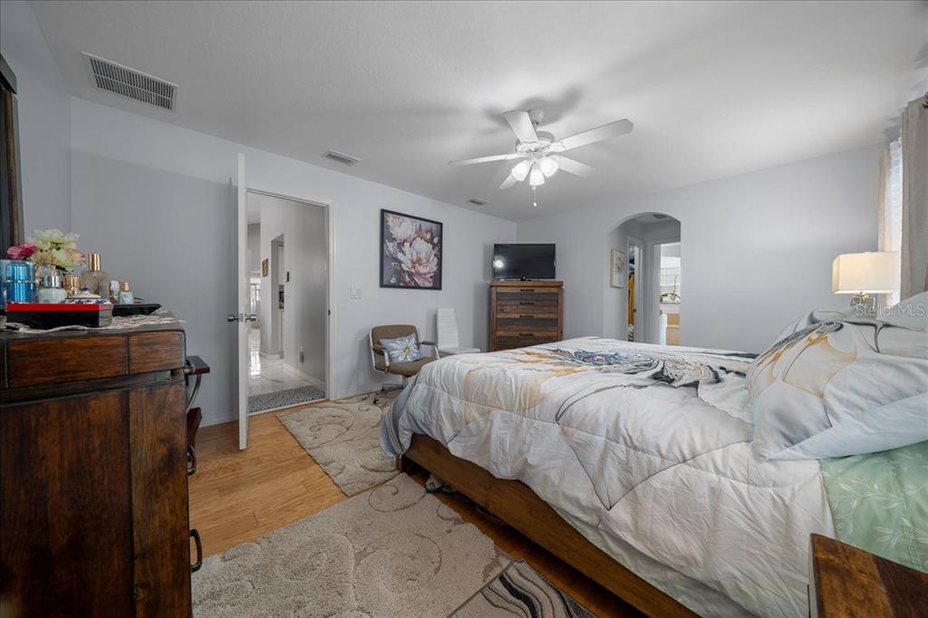 4997 Southwest 107th Loop Ocala, FL 34476 - Photo 19 of 48 a bedroom with a bed and wooden floor