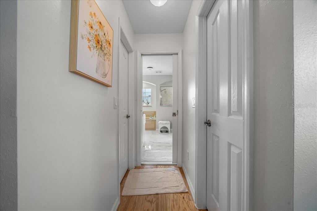 4997 Southwest 107th Loop Ocala, FL 34476 - Photo 21 of 48 a view of a hallway with wooden floor and a bathroom