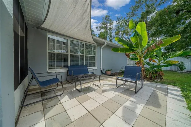 a view of a patio with a table chairs and a yard