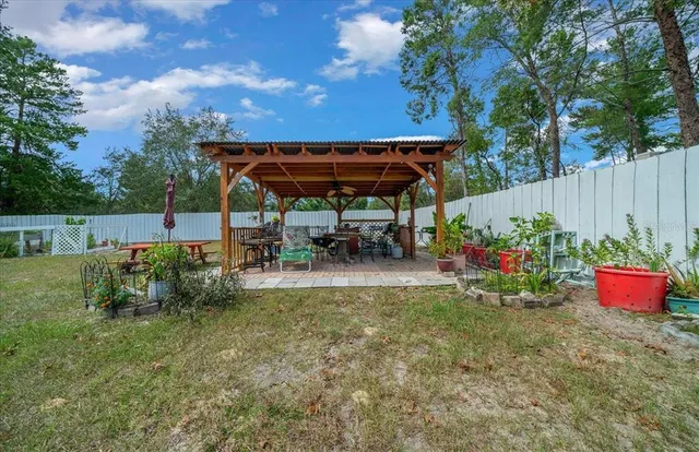 a view of a pool with table and chairs under an umbrella
