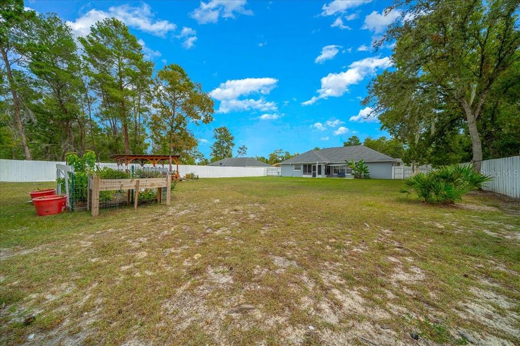 4997 Southwest 107th Loop Ocala, FL 34476 - Photo 44 of 48 a view of a pool with table and chairs under an umbrella