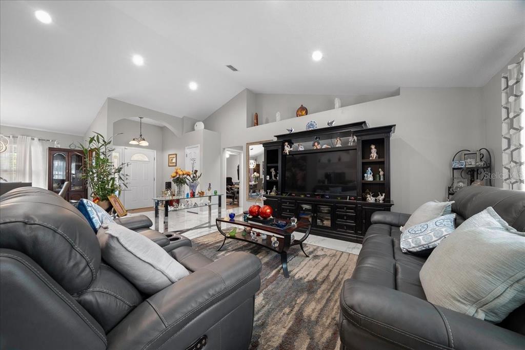 4997 Southwest 107th Loop Ocala, FL 34476 - Photo 8 of 48 a living room with furniture and a flat screen tv