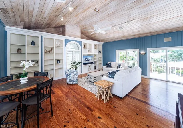 a living room with furniture a wooden floor and next to a window