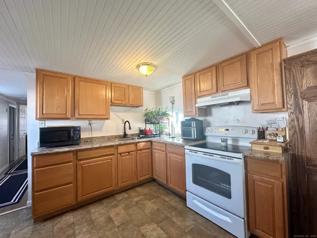 a kitchen with a stove sink and cabinets