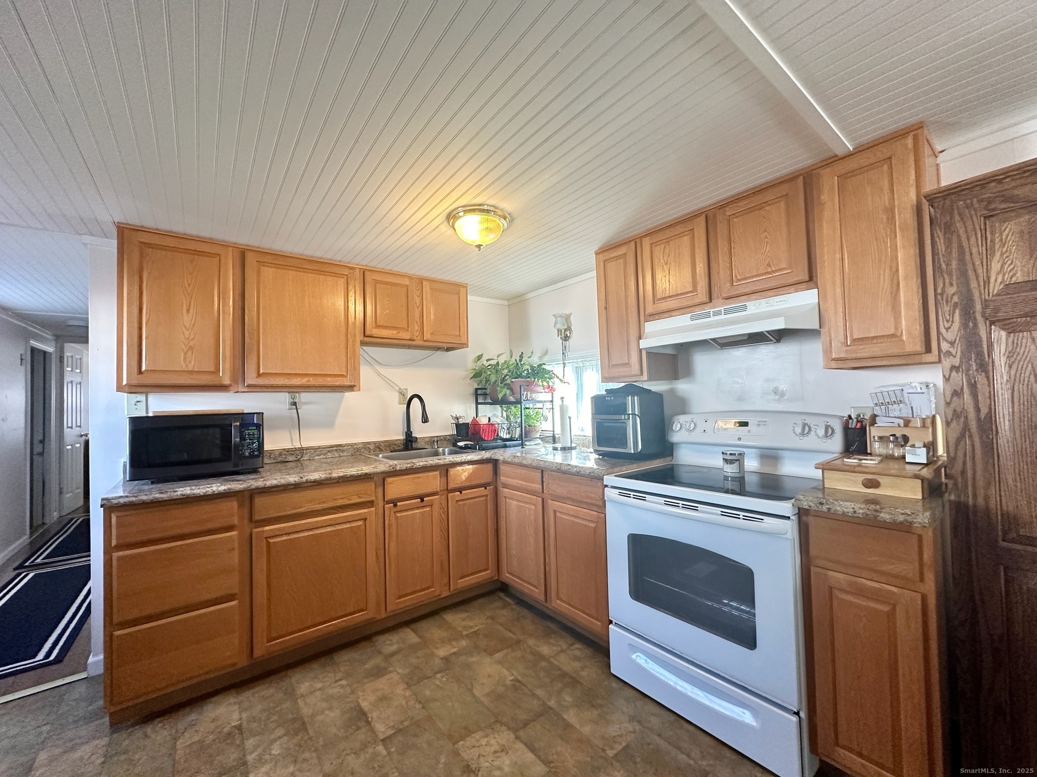 230 Main Street, Unit 63 Wallingford, CT 06492 - Photo 4 of 12 a kitchen with a stove sink and cabinets