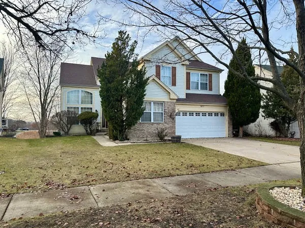 a view of a house with a yard covered in the forest