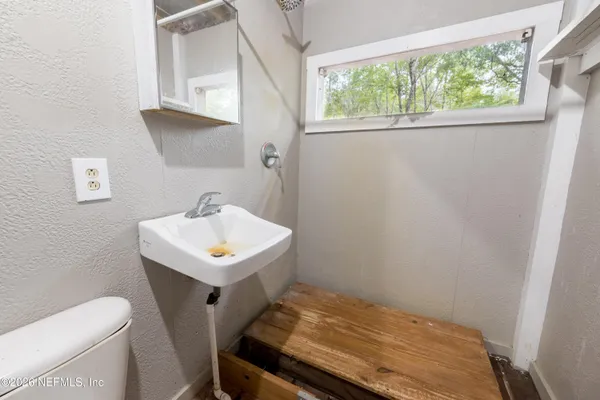 a bathroom with a sink toilet and a window
