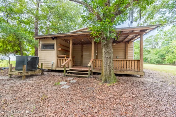 a view of a house with backyard and wooden fence