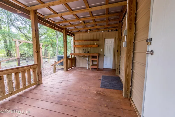 a view of a porch with wooden floor and outdoor space