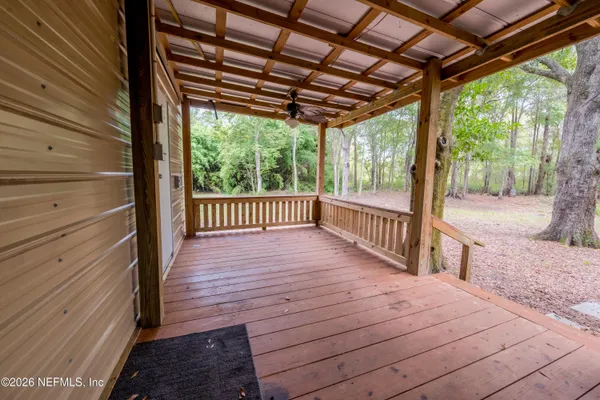 a view of a deck with wooden floor and roof with a floor to ceiling window