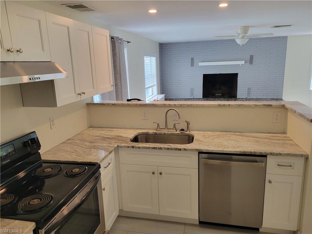 2662 Mangrove Street Naples, FL 34112 - Photo 13 of 31 a kitchen with granite countertop a sink stove and cabinets