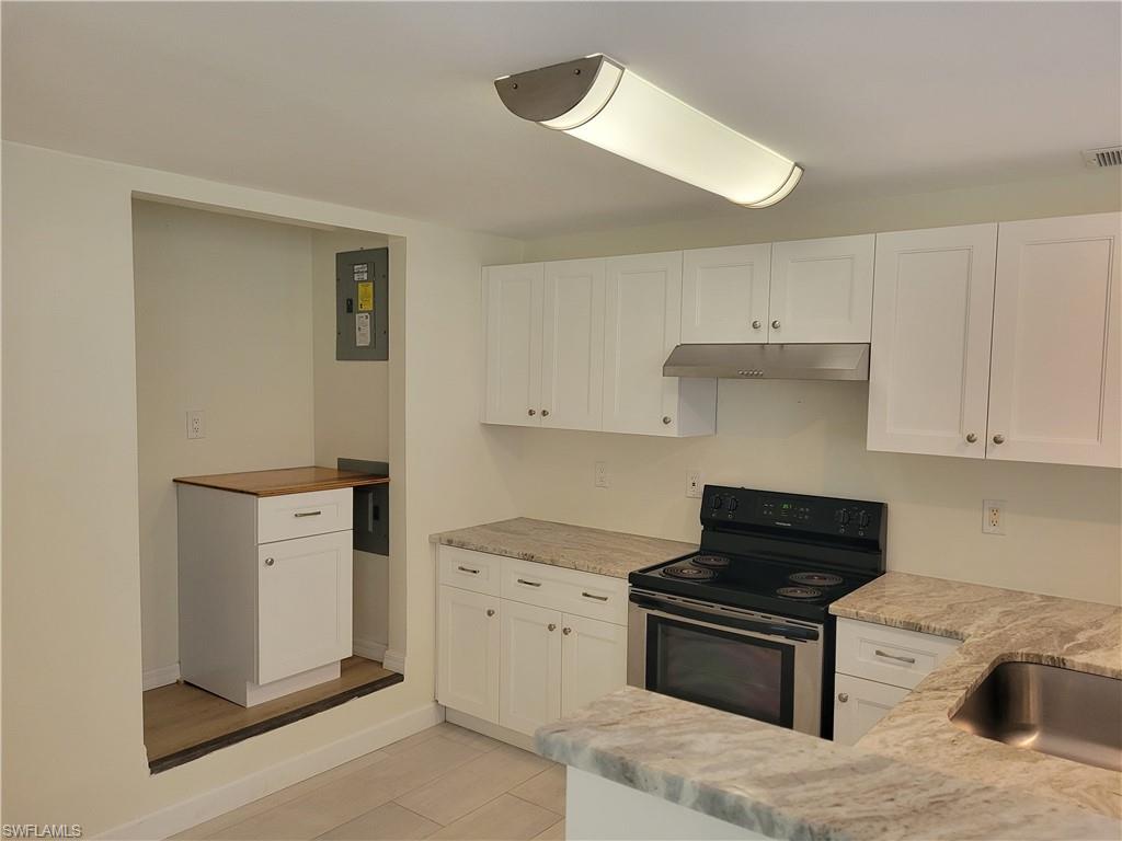 2662 Mangrove Street Naples, FL 34112 - Photo 14 of 31 a kitchen with white cabinets and appliances