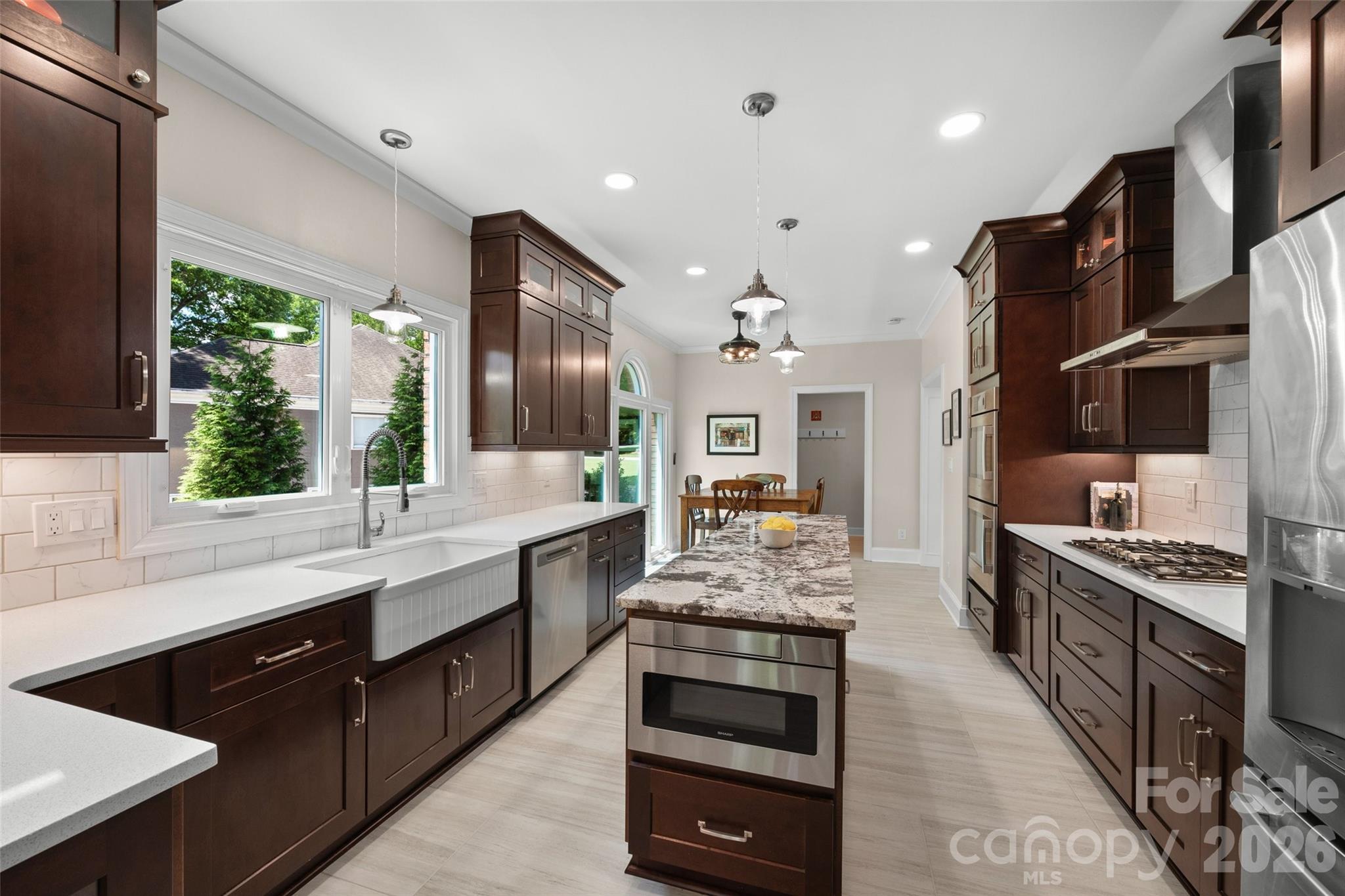 636 Landsdowne Court Fort Mill, SC 29708 - Photo 11 of 48 a large kitchen with stainless steel appliances kitchen island granite countertop a large stove a sink dishwasher and cabinets with wooden floor