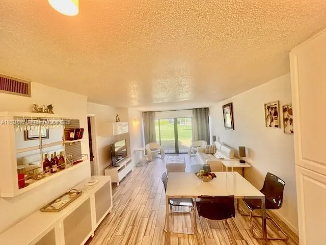 a view of a dining room with furniture a rug and wooden floor