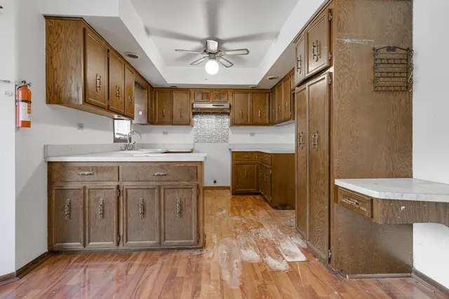 a kitchen with stainless steel appliances granite countertop a sink a stove a refrigerator cabinets and wooden floor