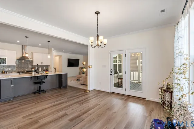 a view of an empty room with wooden floor and windows