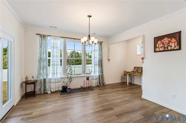 a kitchen with stainless steel appliances kitchen island granite countertop a refrigerator a stove and a wooden floors