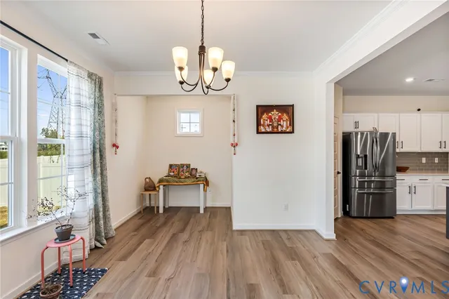 a view of a livingroom with wooden floor and a chandelier