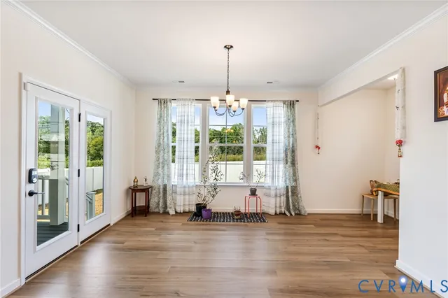 a view of a livingroom with furniture wooden floor a chandelier