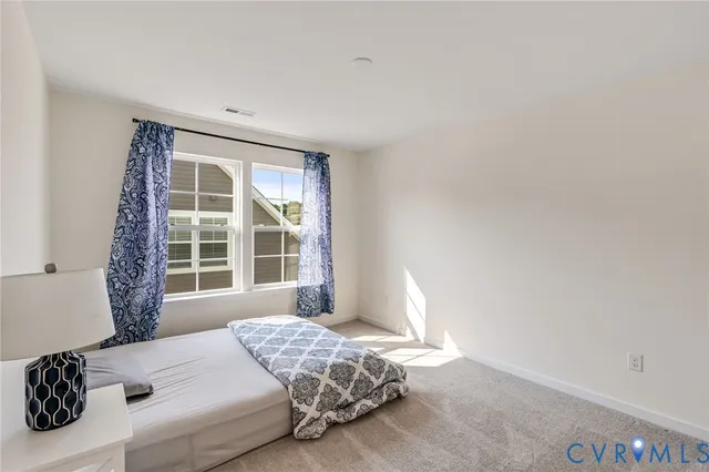 a spacious bedroom with a bed and a chair in it