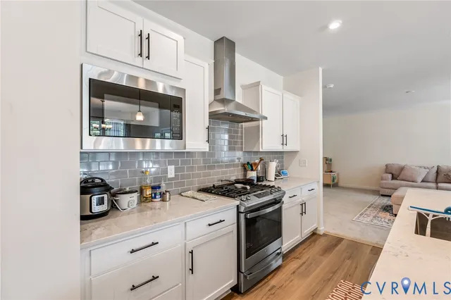 a kitchen with stainless steel appliances a sink stove and cabinets