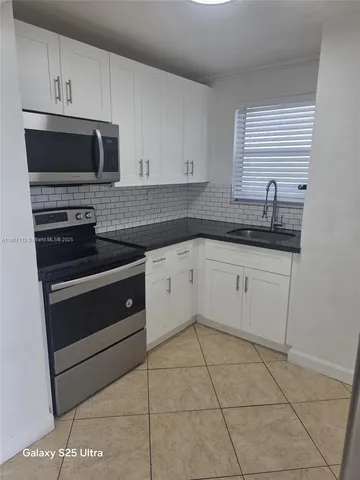 a kitchen with stainless steel appliances a stove a sink and a microwave
