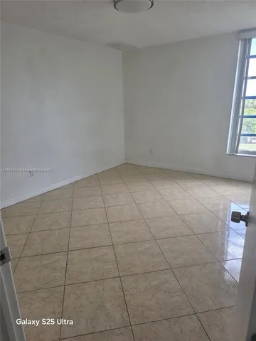 a view of a room with an empty space and window