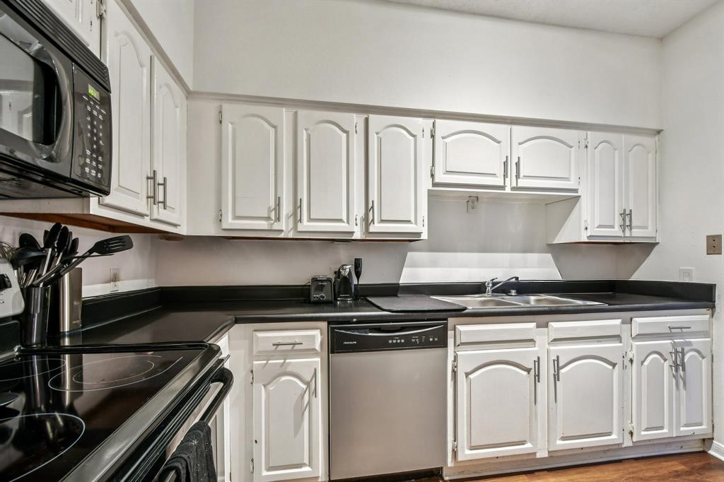 1910 Robbins Place, Unit 301 Austin, TX 78705 - Photo 15 of 29 a white kitchen with granite countertop a sink a stove and cabinets