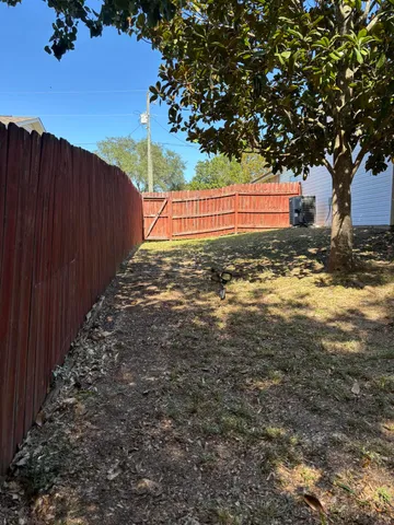 a view of a yard with wooden fence