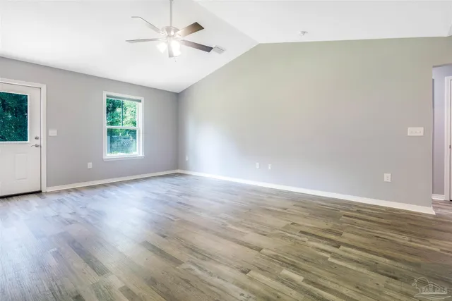a view of an empty room with wooden floor
