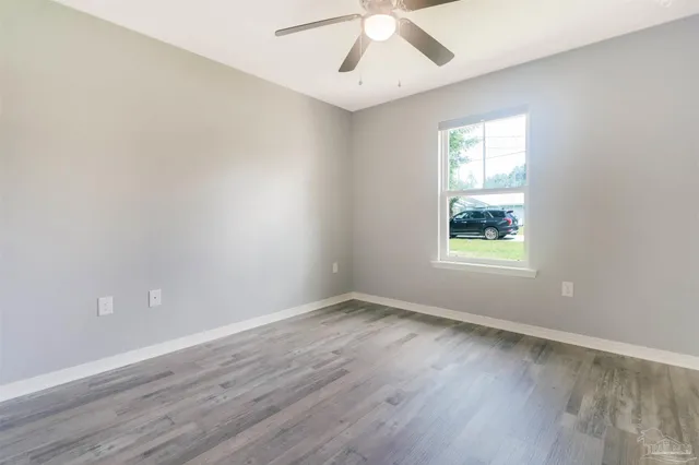 a view of a room that has wooden floor and windows