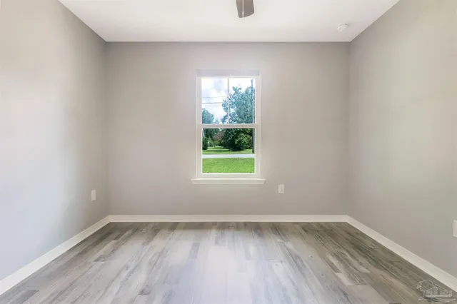 a view of an empty room with wooden floor