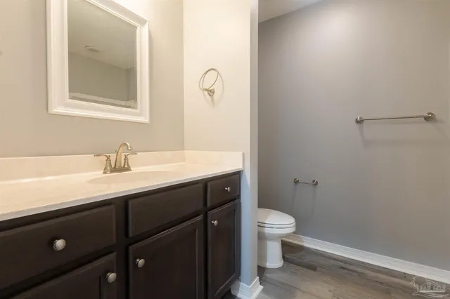 an empty room with wooden floor chandelier fan and windows