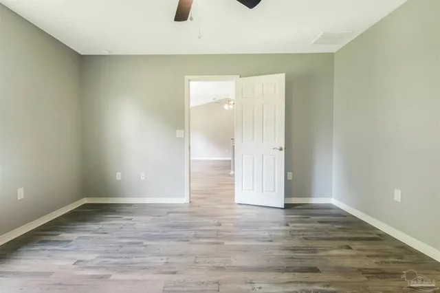 a view of an empty room with wooden floor