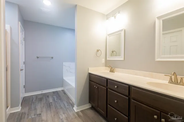 a view of a hallway with wooden floor and closet