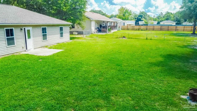 a view of a house with a backyard and a patio