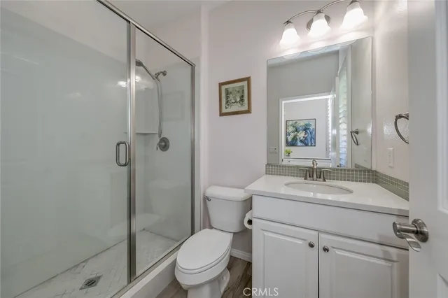 a bathroom with a granite countertop sink toilet a mirror and shower