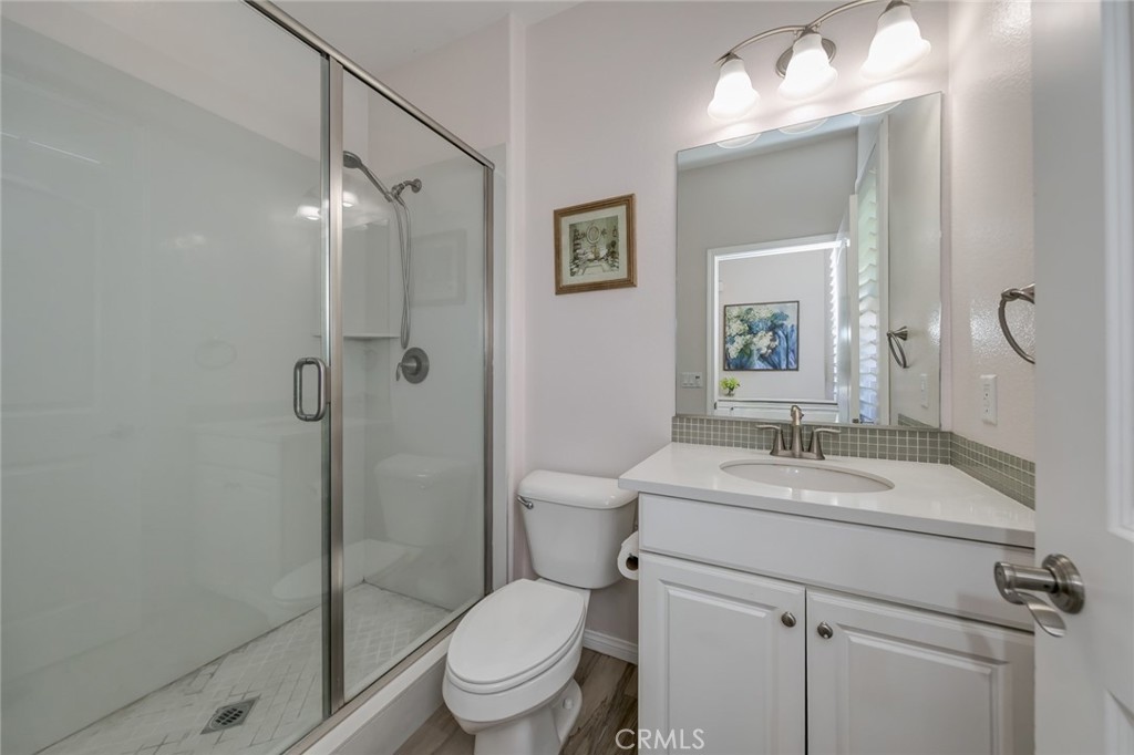 177 Firefly Irvine, CA 92618 - Photo 13 of 22 a bathroom with a granite countertop sink toilet a mirror and shower