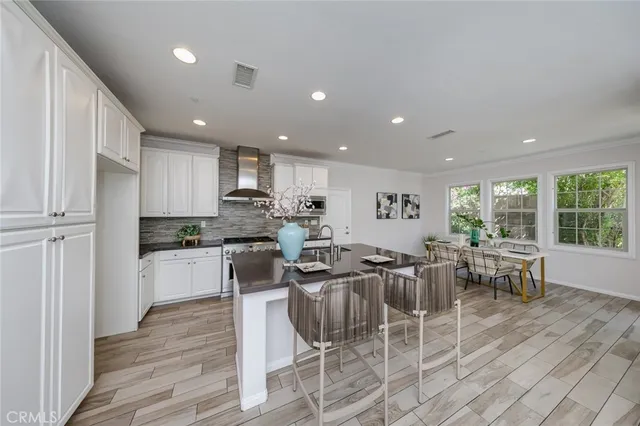 a kitchen with a dining table chairs wooden floor and appliances