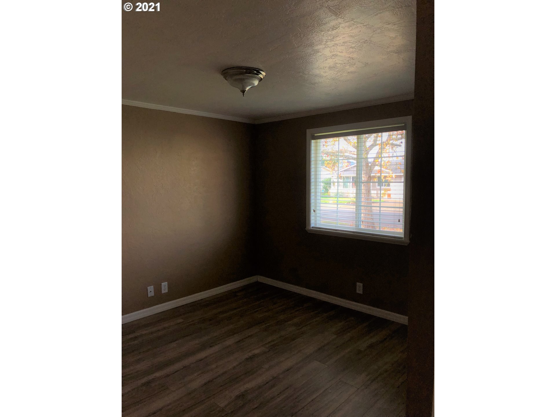 415 38th Street Springfield, OR 97478 - Photo 9 of 17 a view of an empty room with wooden floor and a window