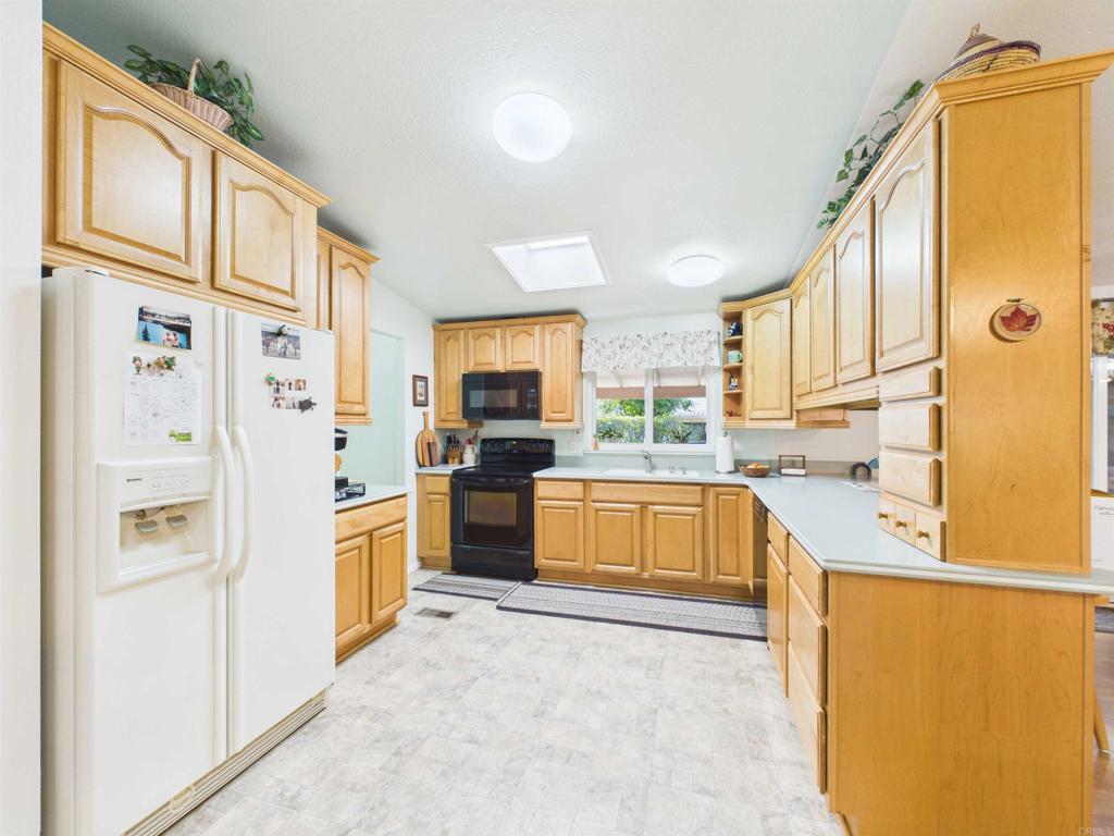 18218 Paradise Mountain Road, Unit 220 Valley Center, CA 92082 - Photo 3 of 48 a kitchen with stainless steel appliances a refrigerator and a stove