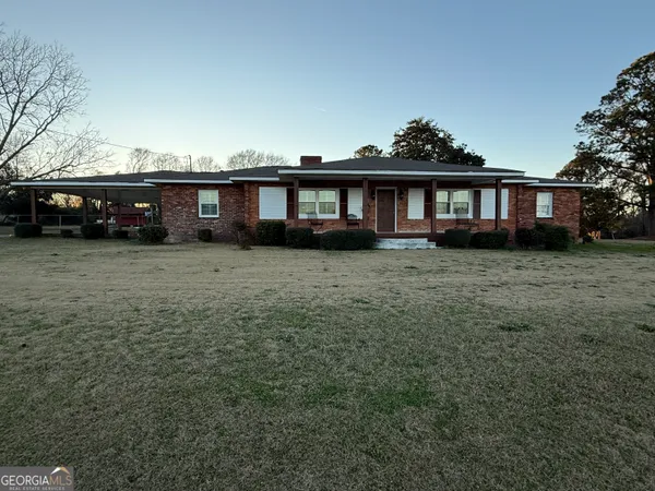 a view of a house with a yard and sitting area
