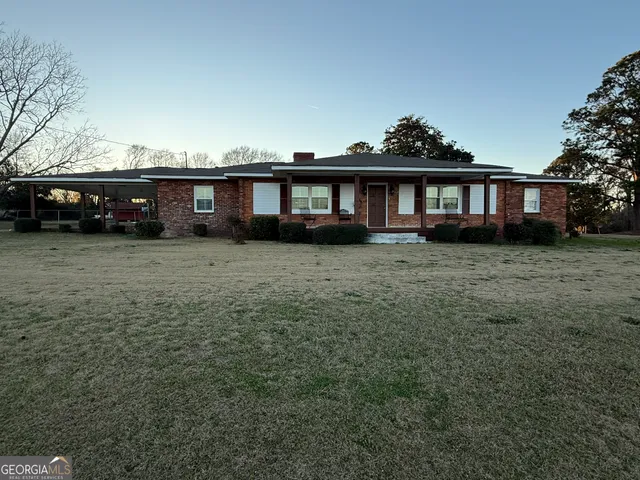 a view of a house with a yard and sitting area