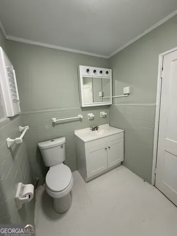 a bathroom with a toilet sink and mirror