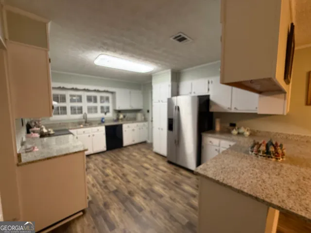 a kitchen with refrigerator and cabinets