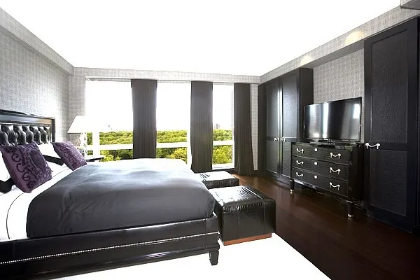 a bedroom with a bed a mirror and a large window